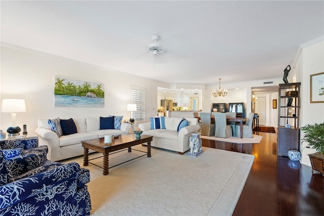 living room with hardwood / wood-style flooring, ceiling fan with notable chandelier, and crown molding