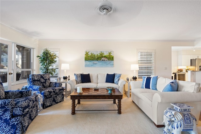 carpeted living room featuring ceiling fan and crown molding