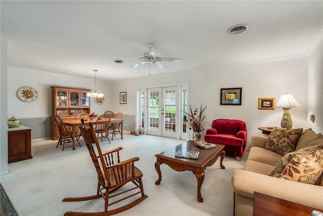 living room with french doors, ceiling fan with notable chandelier, light colored carpet, and crown molding