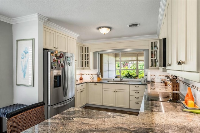 kitchen featuring stainless steel refrigerator with ice dispenser, a textured ceiling, crown molding, and sink