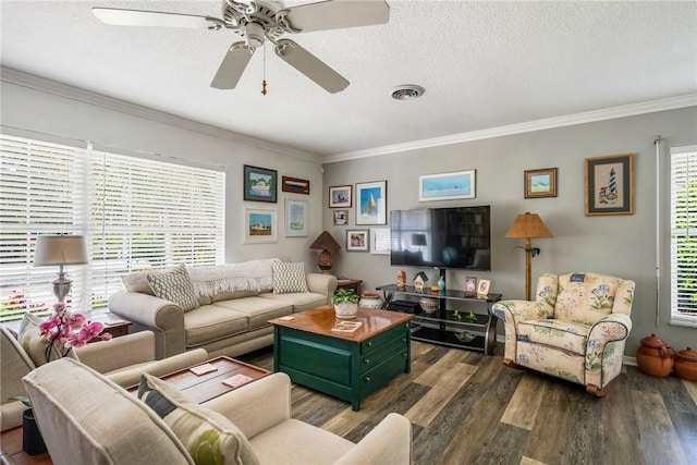 living room featuring a textured ceiling, a healthy amount of sunlight, crown molding, and dark wood-type flooring