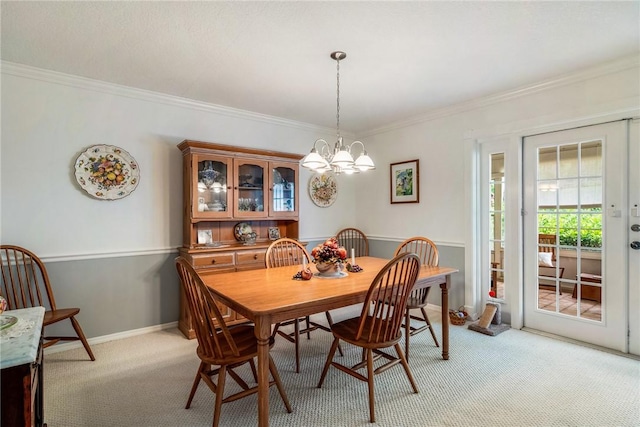 dining space with light carpet, french doors, ornamental molding, and a notable chandelier