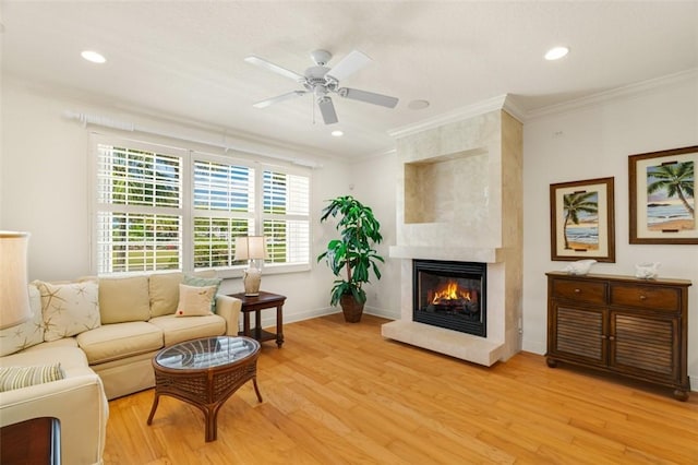 living area with ceiling fan, light wood-style flooring, baseboards, and ornamental molding