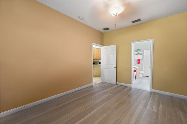 8365 104th Ct, Vero Beach, FL 32967 - unfurnished bedroom featuring light wood-type flooring and ensuite bath