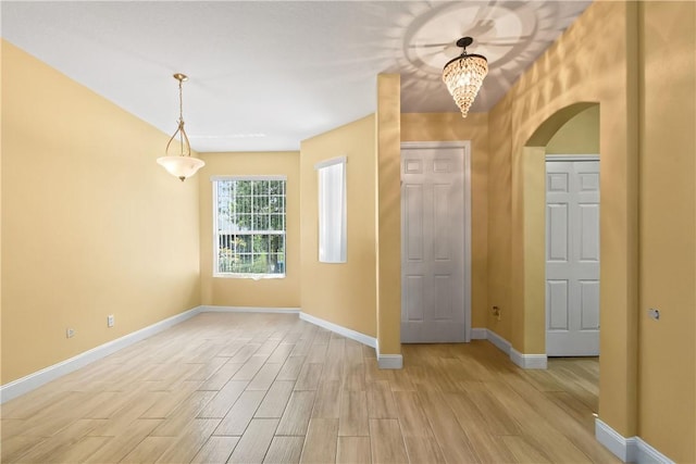 8365 104th Ct, Vero Beach, FL 32967 - entrance foyer with arched walkways, light wood finished floors, and a chandelier
