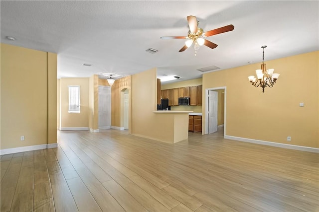 8365 104th Ct, Vero Beach, FL 32967 - unfurnished living room with a ceiling fan, light wood-style floors, arched walkways, and a chandelier