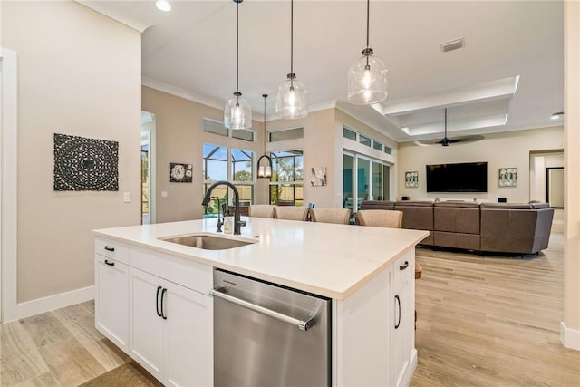 kitchen with stainless steel dishwasher, a sink, ceiling fan, light wood finished floors, and ornamental molding