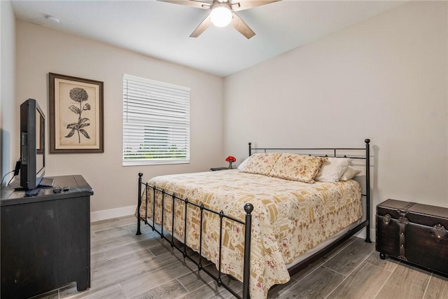 bedroom with wood finished floors, baseboards, and a ceiling fan