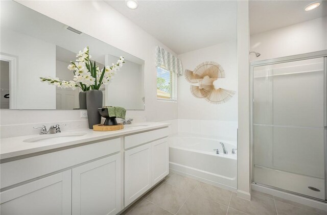 502 Saunders St, Sebastian, FL 32958 - full bath with tile patterned flooring, a stall shower, a garden tub, double vanity, and recessed lighting