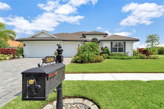 8280 Halbert Ln, Vero Beach, FL 32968 - view of front of home with decorative driveway, an attached garage, a front lawn, and stucco siding