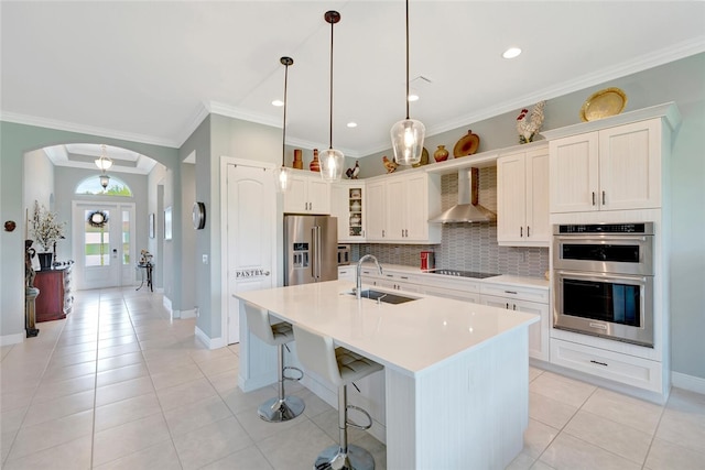 8280 Halbert Ln, Vero Beach, FL 32968 - kitchen with a sink, appliances with stainless steel finishes, wall chimney range hood, arched walkways, and backsplash
