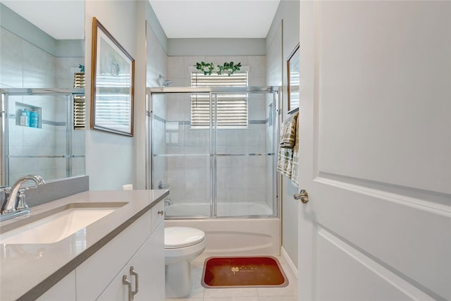 8280 Halbert Ln, Vero Beach, FL 32968 - full bath with bath / shower combo with glass door, vanity, toilet, and tile patterned flooring