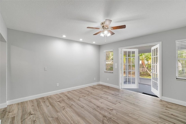 spare room with ceiling fan, light hardwood / wood-style floors, and a textured ceiling