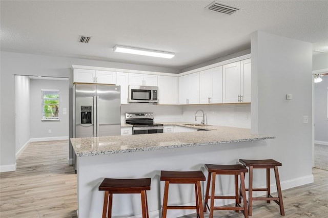 kitchen with decorative backsplash, appliances with stainless steel finishes, white cabinetry, and sink