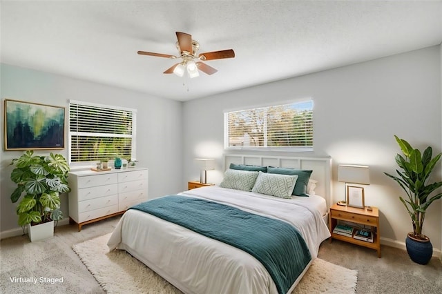 carpeted bedroom with multiple windows and ceiling fan