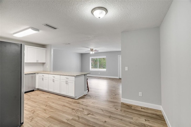 kitchen featuring white cabinetry, kitchen peninsula, stainless steel refrigerator, and light wood-type flooring