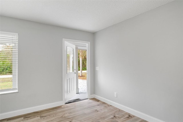 entryway with light hardwood / wood-style floors and a textured ceiling