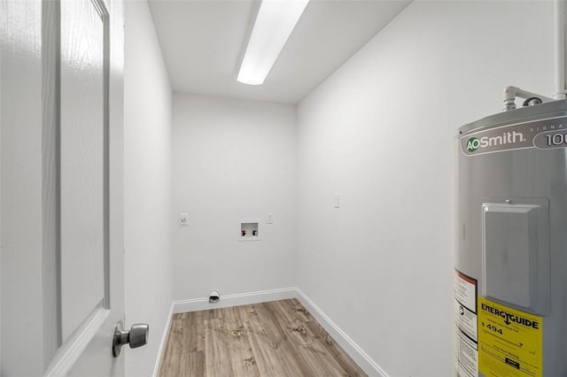 washroom featuring hardwood / wood-style flooring, water heater, hookup for a washing machine, and hookup for an electric dryer