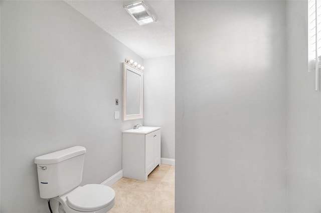 bathroom with tile patterned floors, a textured ceiling, vanity, and toilet