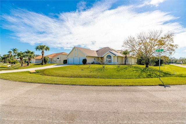 ranch-style home featuring a front lawn and a garage