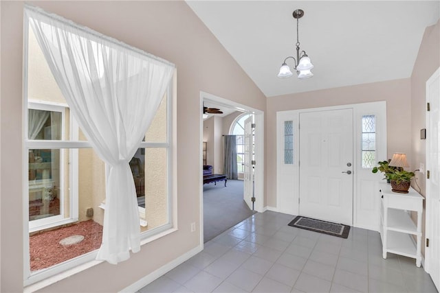 tiled foyer entrance featuring a chandelier and lofted ceiling