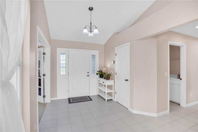 entryway with light tile patterned floors, lofted ceiling, and a notable chandelier