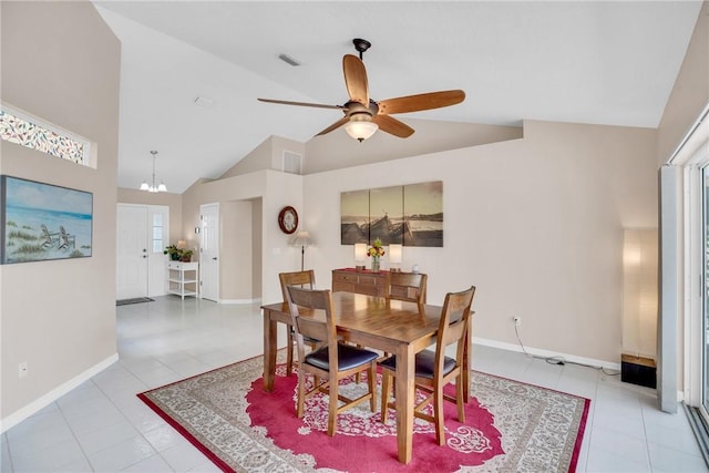 tiled dining space featuring high vaulted ceiling, plenty of natural light, and ceiling fan with notable chandelier