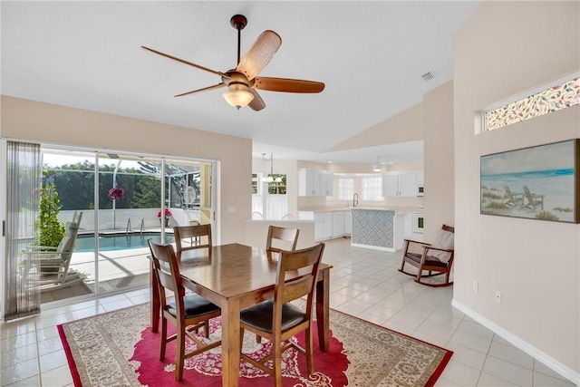 dining space with ceiling fan, sink, light tile patterned flooring, and lofted ceiling