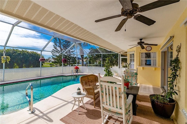 view of pool featuring ceiling fan, glass enclosure, and a patio