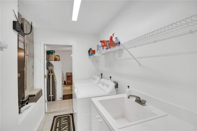 washroom with cabinets, sink, independent washer and dryer, and light tile patterned flooring