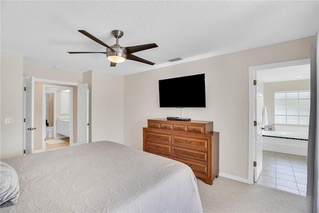 carpeted bedroom with ceiling fan and ensuite bath