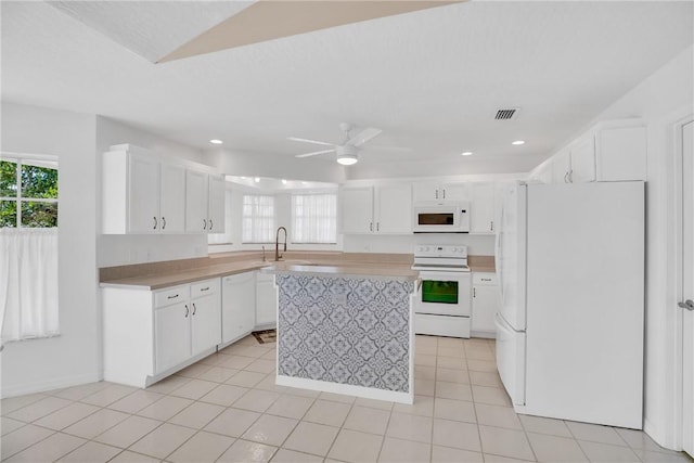 kitchen featuring light tile patterned floors, ceiling fan, white cabinetry, and white appliances