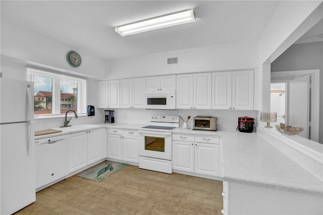 kitchen featuring white cabinetry, sink, white appliances, and light hardwood / wood-style floors