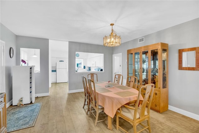 dining area featuring light hardwood / wood-style flooring and a chandelier