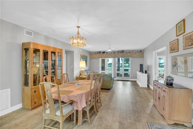 dining area featuring ceiling fan with notable chandelier and light wood-type flooring