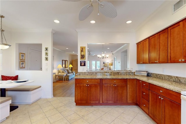 kitchen featuring crown molding, kitchen peninsula, pendant lighting, light stone counters, and ceiling fan with notable chandelier