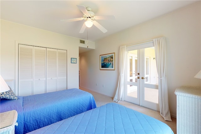 bedroom featuring light colored carpet, ceiling fan, and a closet