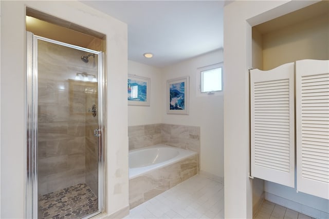 bathroom featuring shower with separate bathtub and tile patterned flooring