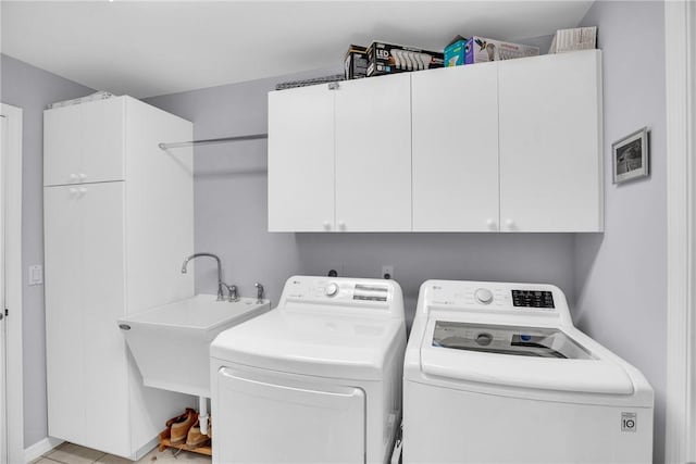 clothes washing area featuring cabinet space and washing machine and dryer