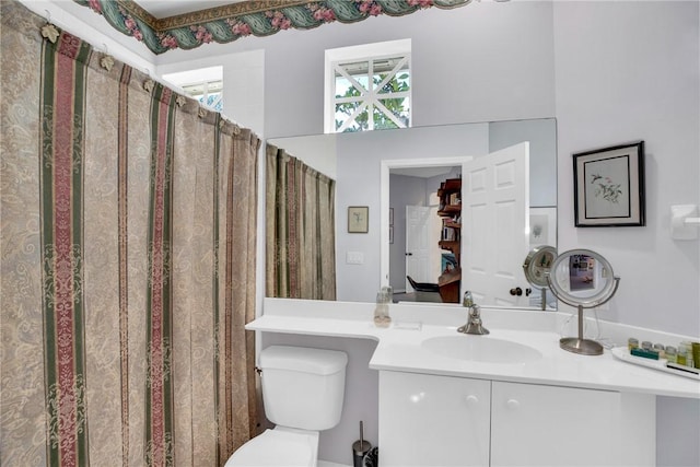 bathroom with a shower with shower curtain, vanity, and toilet