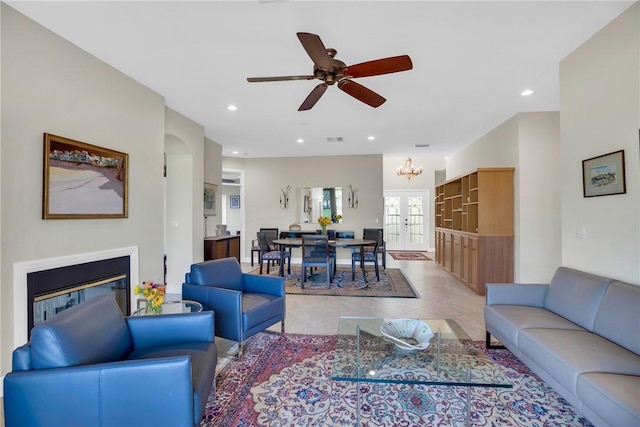 living room featuring french doors, light tile patterned floors, recessed lighting, visible vents, and a glass covered fireplace