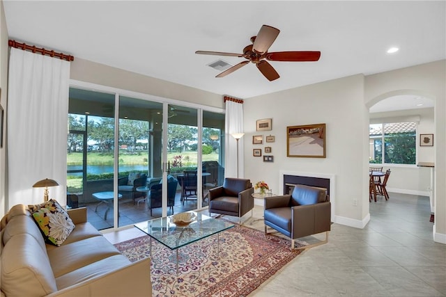 living area with recessed lighting, a ceiling fan, visible vents, baseboards, and a glass covered fireplace