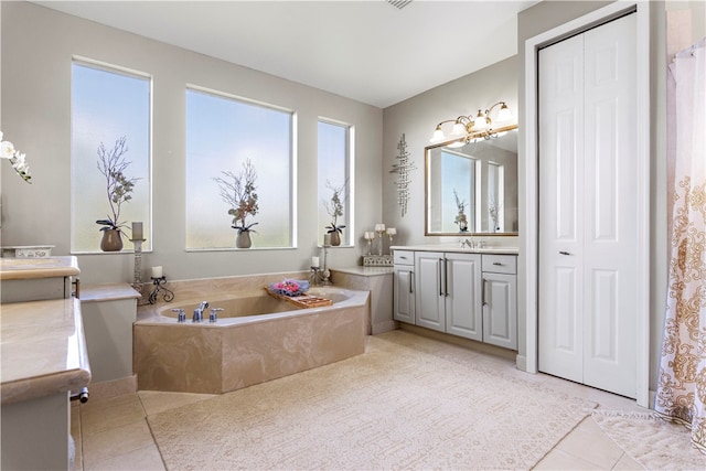 bathroom with vanity, tiled bath, and tile patterned floors