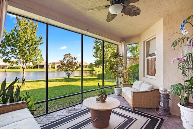 sunroom / solarium with a water view and ceiling fan