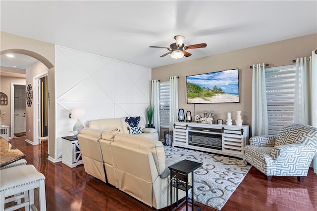 living room featuring ceiling fan and dark hardwood / wood-style floors