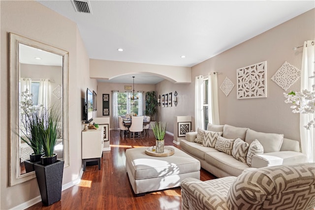 living room featuring dark wood-type flooring and a chandelier