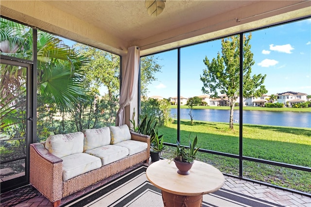 sunroom featuring a water view