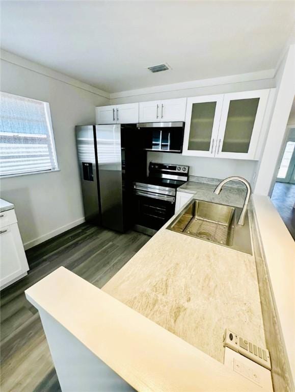 kitchen featuring appliances with stainless steel finishes, white cabinetry, dark hardwood / wood-style flooring, sink, and crown molding