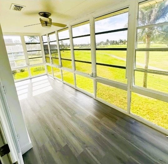 unfurnished sunroom featuring ceiling fan