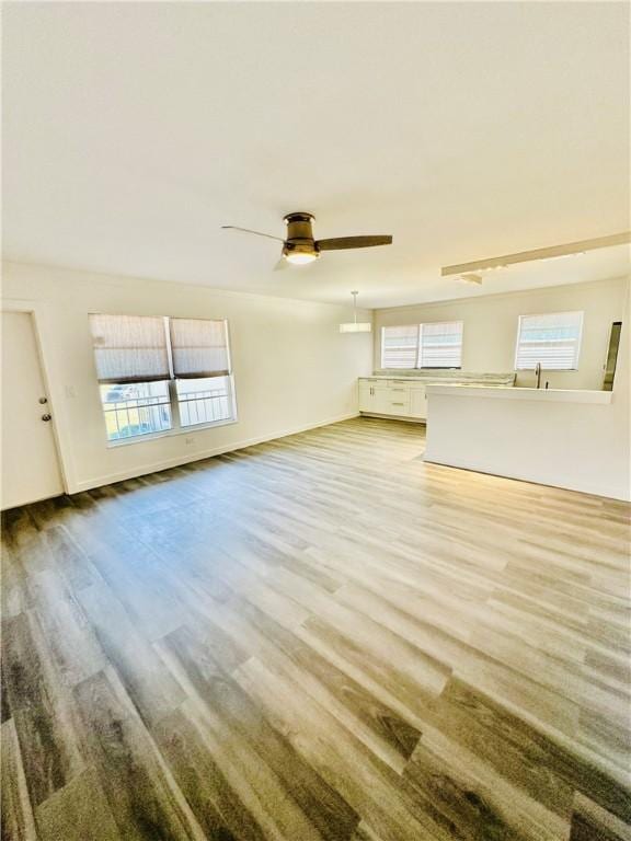 unfurnished living room with ceiling fan